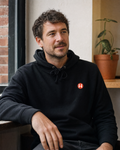 PREFER HUMANS hoodie worn by a man in a relaxed independent cafe setting